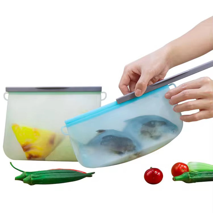 Händer skjuter på förslutningsskenan på en blå FreshSeal silikonpåse med fisk.